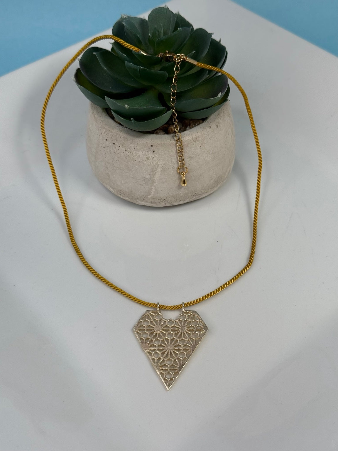 Collar de corazón calado con hilo de nylon y extensión.
