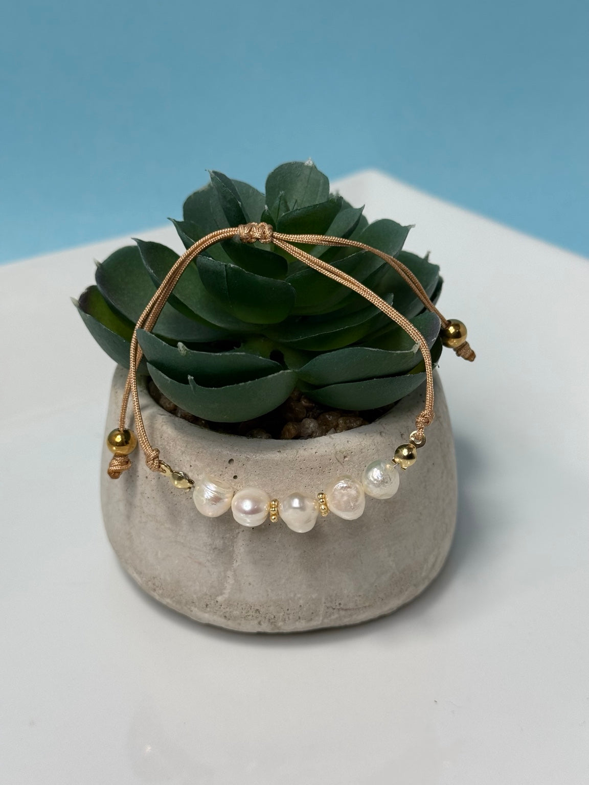 Pulsera ajustable de perlas de agua dulce con detalles en stainless steel