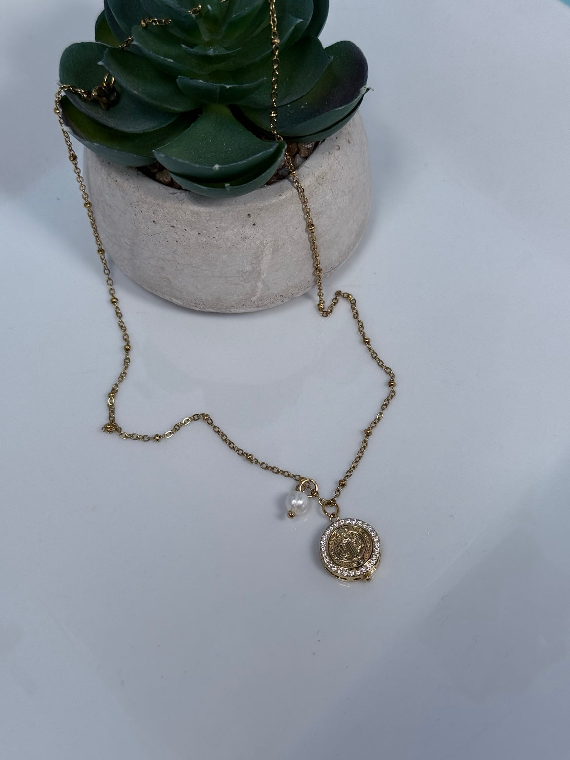 Cadena de 18 pulgadas stainless steel con dije de San Benito en circonias y detalle de perla