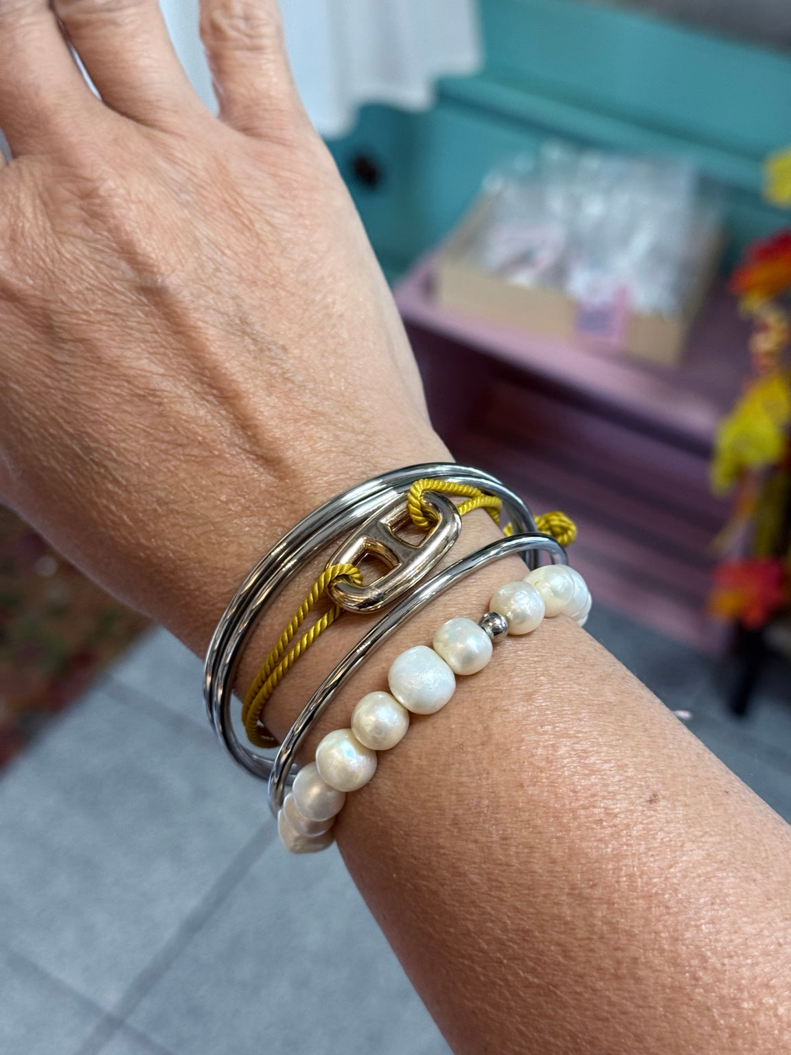 Set de tres bangles plateados en la muñeca