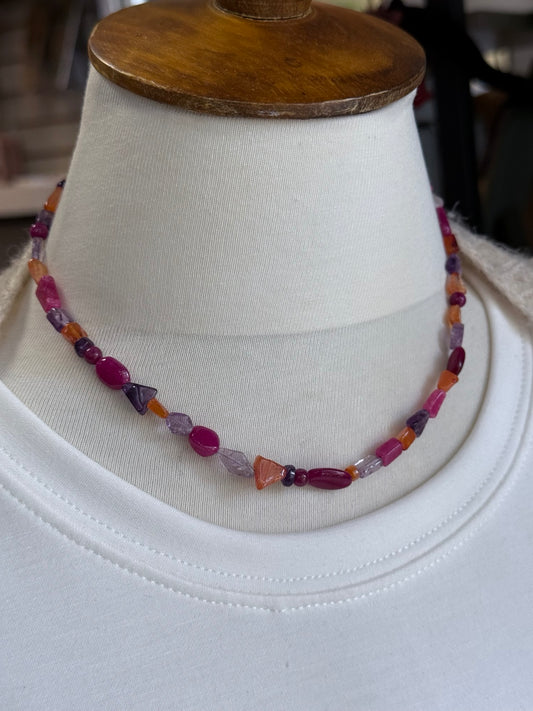 Collar artesanal de ágatas de colores mostrado sobre busto.