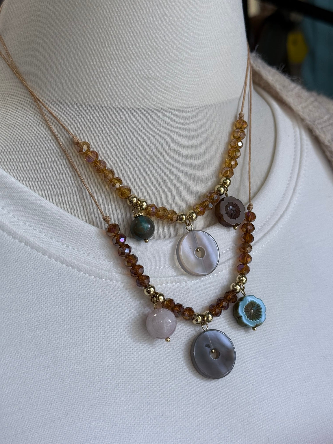 Dos collares ajustables con cristal checo y ágatas, mostrados sobre busto.