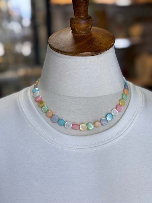 Collar de madreperla multicolor mostrado sobre busto.