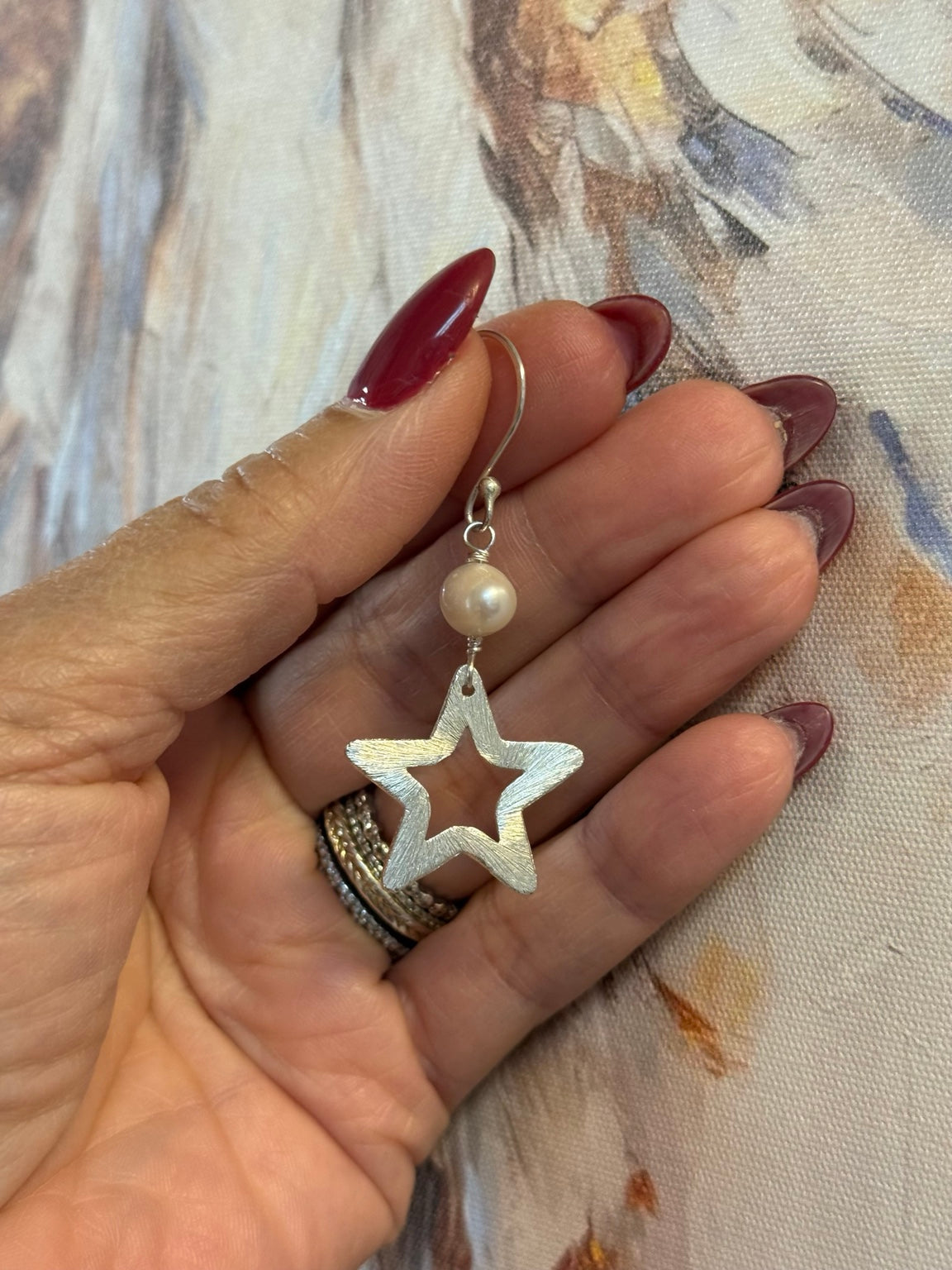 Detalle de pantalla enchapada en plata con perla y estrella