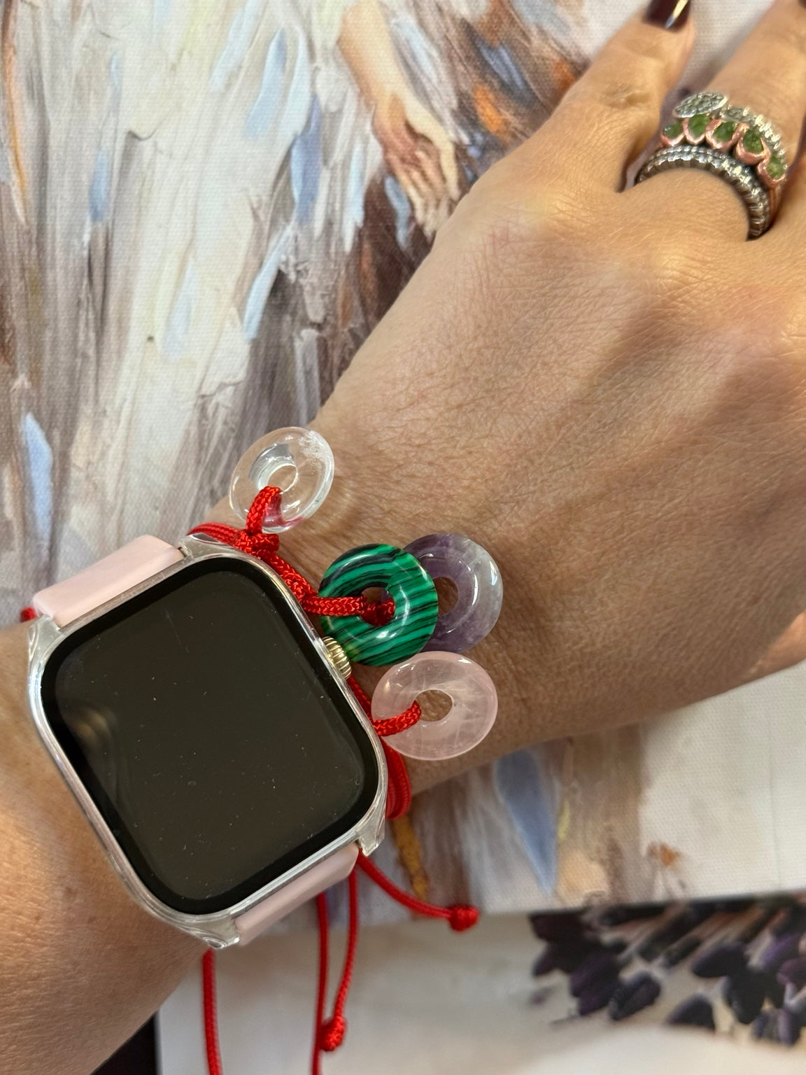 Detalle de pulseras de aro de cuarzo con cordón rojo en la muñeca