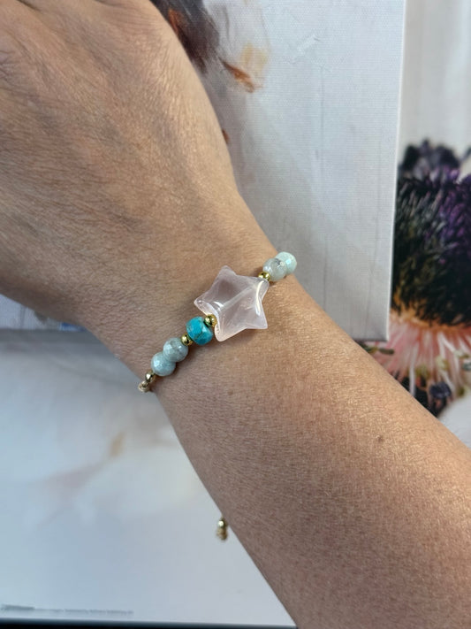 Pulsera artesanal ajustable de cuarzo rosado, amazonita y turquesa mostrada en la muñeca.
