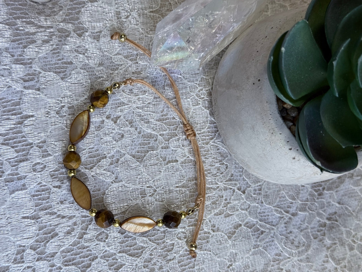 Detalle de pulsera ajustable de madreperla y ojo de tigre