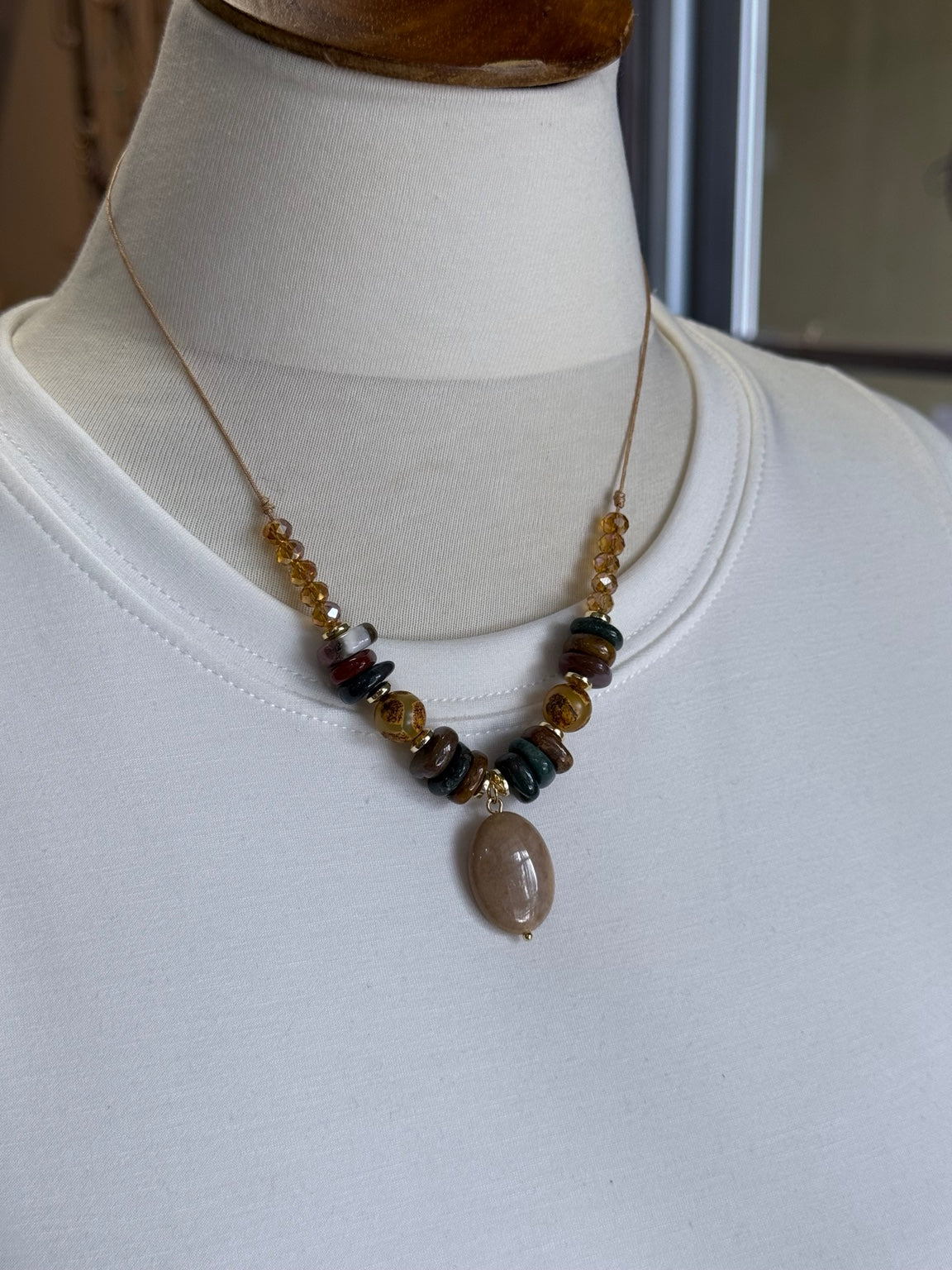 Collar ajustable con jaspe, ágatas tibetanas y cristal mostrado sobre busto.
