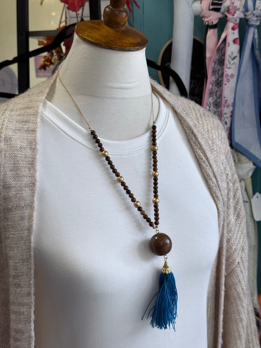 Set de collar ajustable de madera con borla turquesa mostrado sobre busto.